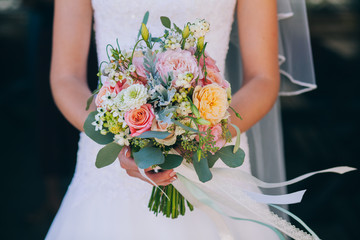 Beautiful wedding bouquet in hands of the bride