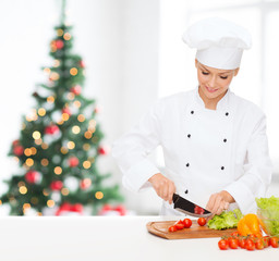 smiling female chef chopping vegetables