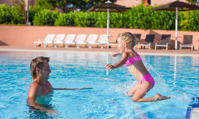Obraz na płótnie Canvas Father and little girl enjoy swimming in the pool