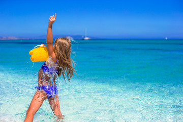 Adorable little girl playing with toy on beach vacation