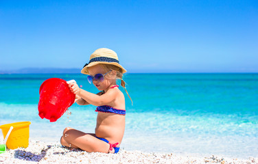 Adorable little girl playing with toy on beach vacation
