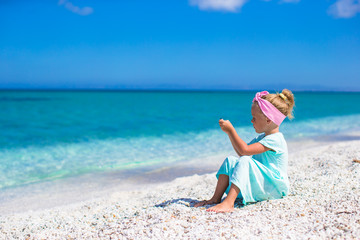 Little adorable girl take picture of the sea on phone at