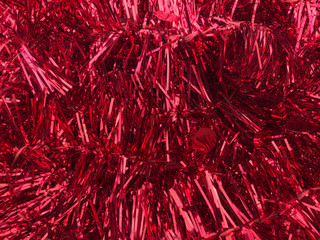 Christmas red tinsel garland closeup, background.