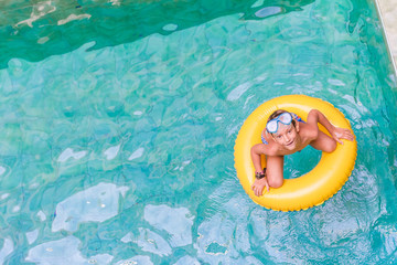 Swimming, summer vacation - lovely child boy playing in blue wat