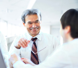 A business team of three sitting in office