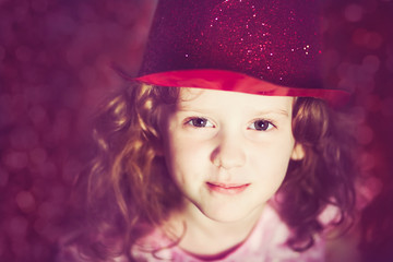 Close-up portrait of a little girl in shiny red hat. Instagram f