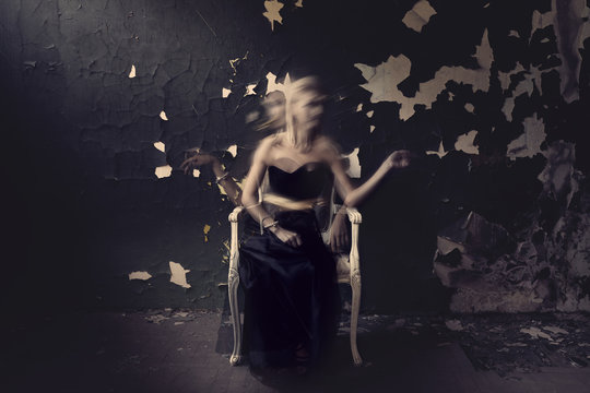 Ghost woman in black on a chair. Grunge room