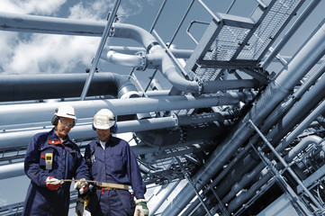 oil and gas workers with giant pipelines constructions