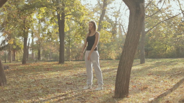 Beautiful girl doing fitness in a park in autumn
