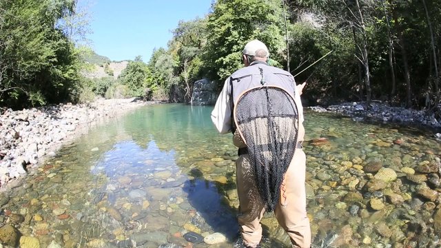 Fisherman fly fishing in trout river