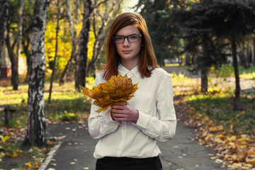 girl teen with autumn leaves in the hands