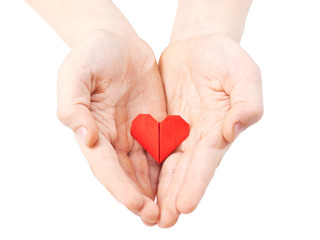 red paper origami heart in childs hand isolated on white background