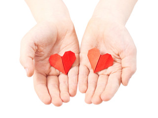 Obraz premium origami paper hearts in child hands isolated on white background