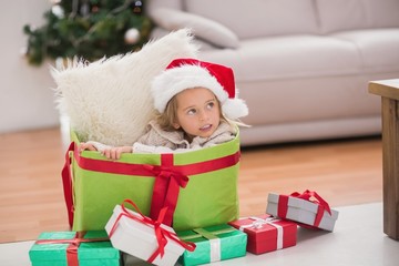 Cute little girl sitting in giant christmas gift