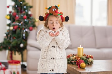 Festive little girl blowing over hands