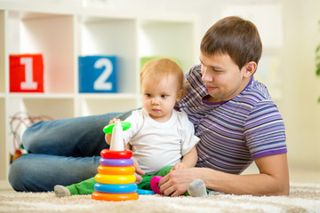 father and baby boy play together indoor at home