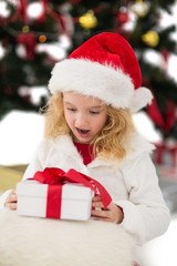 Fototapeta na wymiar Festive little girl looking at gift