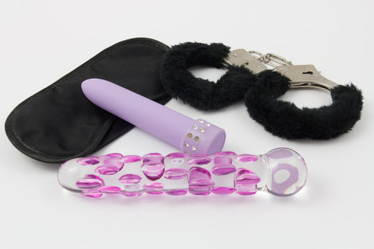 Sex Toys - Maske, Handschellen, lila Vibrator und Glas Dildo