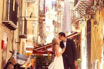 Happy bride and groom walking in the city of Sicily