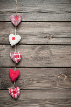 Red hearts hanging over old wood background