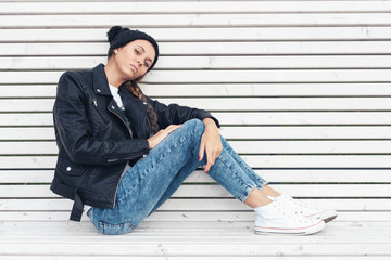 Beautiful young girl sitting  on a white bench in the park