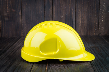 Construction hard hat on wooden background