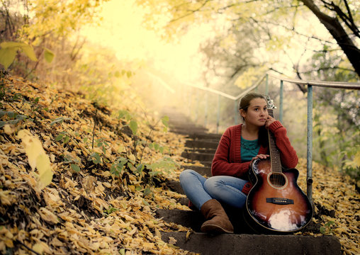Young woman inloved with her guitar