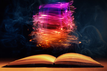Open book with magic lights on dark background