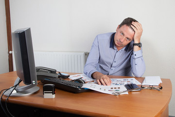 Homme au bureau main sur la tête