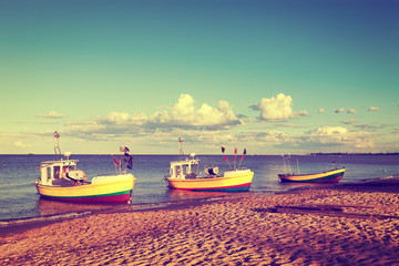 Fototapeta premium Fishing boats is moored in beach. Vintage toned photo.