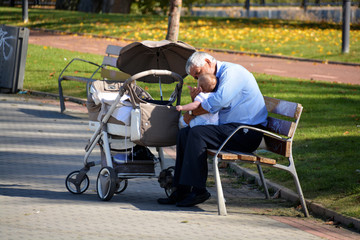 abuelo dando de comer a su nieto en un parque