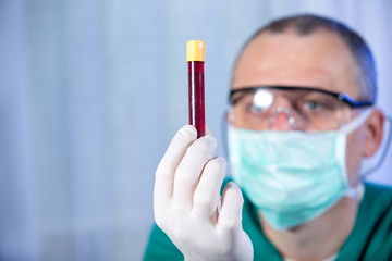 Young man studying liquid sample contained in a test-tube