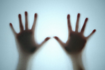 Hands silhouette behind a transparent blue fabric