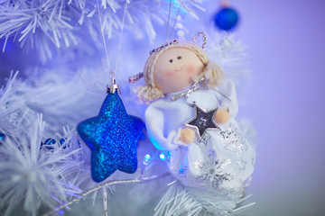 Christmas toys in the form of an angel hanging on the tree next