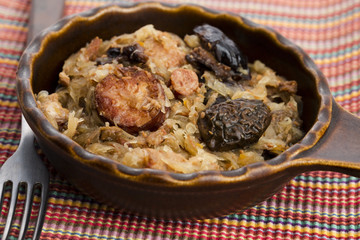traditional polish sauerkraut (bigos) with mushrooms and plums