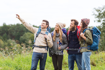 group of friends with backpacks taking selfie