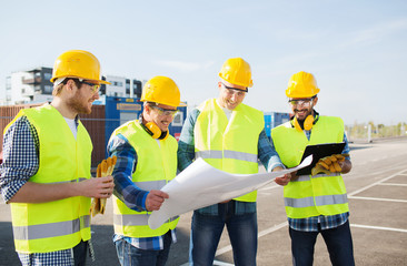 group of builders with tablet pc and blueprint