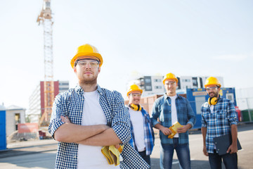group of smiling builders in hardhats outdoors