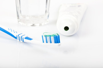 Zahnbürste mit Zahnpasta, Tube und Wasserglas