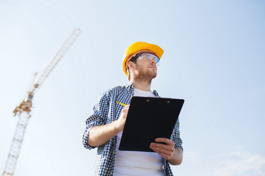 builder in hardhat with clipboard outdoors