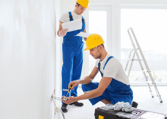 builders with tablet pc and equipment indoors