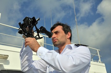 navigator with sextant on the watch on sea going vessel - 72795149