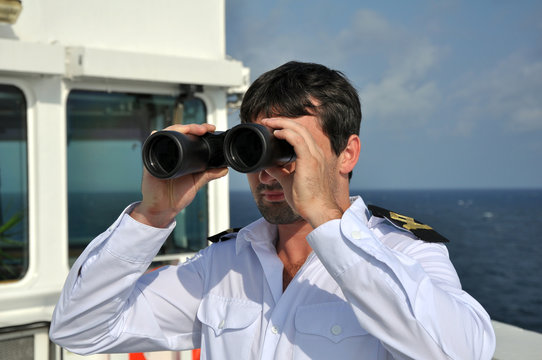 navigator on navigation bridge during his watch  with binocular