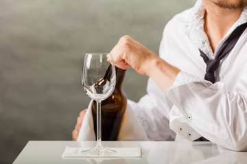 Man waiter pouring wine into glass.