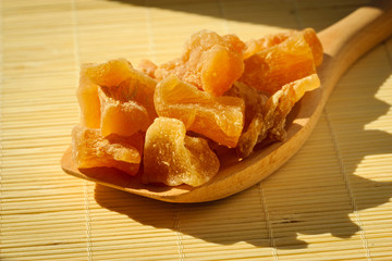 Closeup candied ginger on wooden spoon