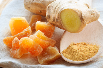 Candied fresh and ground ginger on rustic table