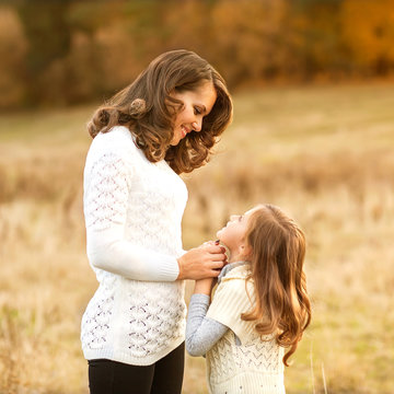 mother and daughter walking in autumn in a field