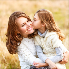 mother and daughter hugging in love playing in the park
