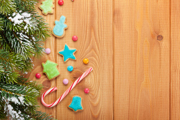 Christmas wooden background with snow fir tree, gingerbread cook