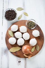 Cutting board with raw khinkali and ingredients, high angle view
